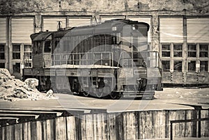 Alone Soviet old train in winter against the background of the railway depot hangars and rails