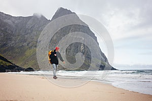 Adventure traveler with backpack hiking by ocean sand photo
