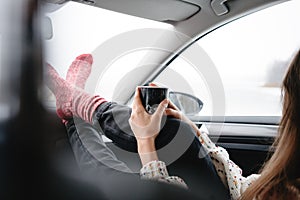 Alone traveler boho woman wearing scarf rest in car and looking away of winter landscape while her journey