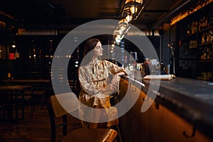 Alone woman with glass of wine sitting in bar
