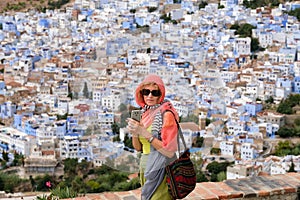 Alone woman observing the Chefchaouen town in Morocco