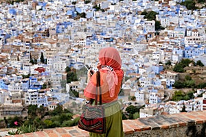 Alone woman observing the Chefchaouen town in Morocco