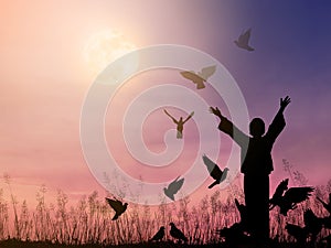Alone woman praying and free bird flying to the dramatic sky background