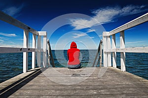 Alone Woman in Red Shirt at the Edge of Jetty