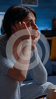 Alone woman sitting on couch feeling disappointed