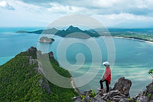 Alone young woman success hiking on top of mountain with sea and