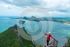 Alone young woman success hiking on top of mountain with sea and