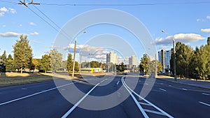 Along the city street there are residential houses with balconies, trees, lampposts and parked cars. Nearby is a paved roadway wit