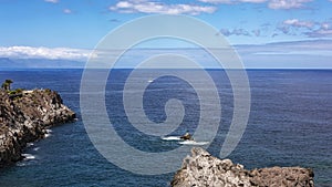 Along the rocky shore of Los Gigantos sailboat sails with white