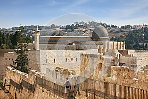 Along the walls of Jerusalem strolls woman pilgrim