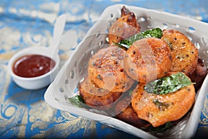 aloo chops. aloor chops. potato cutlet.aloo tikki in a white plate with curry leaves and white chutni