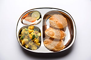 Aloo Fry OR Bombay potatoes and puri/Poori in a stainless steel oval plate