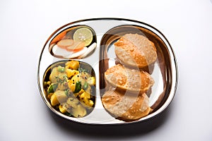 Aloo Fry OR Bombay potatoes and puri/Poori in a stainless steel oval plate photo