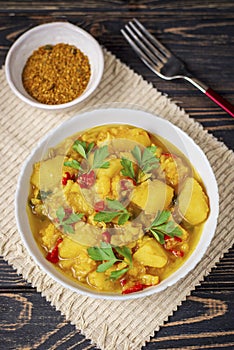 Aloo Gobi side dish. Traditional spicy vegetarian indian curry dish with potatoes, cauliflower, spinach with spices