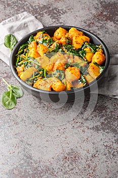 Aloo Palak sabzi Spinach Potatoes curry served in a bowl closeup. Vertical