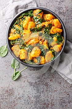 Aloo Palak sabzi Spinach Potatoes curry served in a bowl closeup. Vertical top view