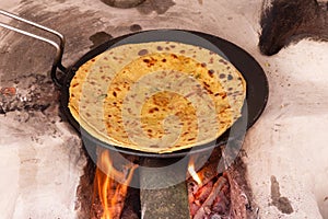Aloo Paratha, cooking on traditinal wood fire stove chulha, top side view photo