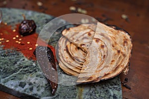 Aloo Paratha / Indian Potato stuffed Flat bread in white plate. on wooden table