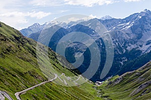 Alp road surrounded by blue alp high mountains. Steep descent of Passo dello Stelvio in Stelvio Natural Park