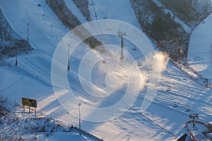 Alpencia, South Korea, 2016, winter - General plan. Snow cannons cover the ski slope with snow on an empty track. Snow slide for