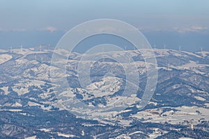 Alpencia, South Korea, 2016, winter - General plan. White windmills stand on top of snow-capped mountains