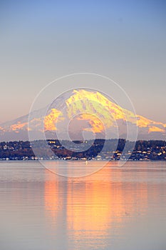 Alpenglow on Mount Rainier reflects on Puget Sound