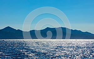 Alpes rocky mountains over Golfe de la Napoule Gulf at Mediterranean Sea of French Riviera offshore Cannes in France photo