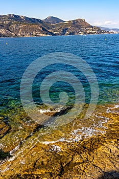 Alpes rocky shore at French Riviera of Mediterranean Sea seen from Saint-Jean-Cap-Ferrat resort town in Cap Ferrat cape in France