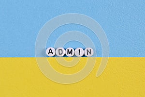 Alphabet beads with text ADMIN isolated on blue and yellow background