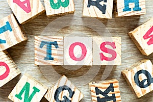 Alphabet block in word TOS abbreviation of Terms of service with another on wood background photo