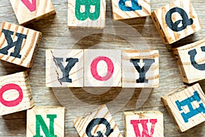 Alphabet block in word YOY abbreviation of year over year with another on wood background