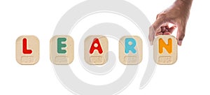 Alphabet blocks spelling the word LEARN with Braille