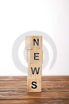 alphabet cubes making word news on wooden table, on white