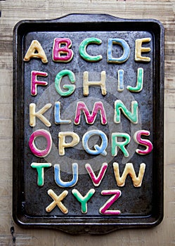 Alphabet in decorated colourful cookies on baking tray