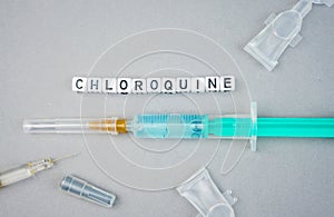 Alphabet dices with the word Chloroquine and syringe a possible treatment for Corona Virus