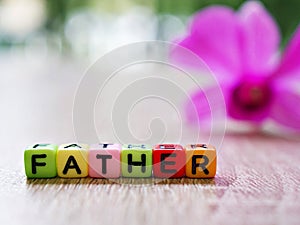 Alphabet `Father` beads in cube shape with blurred background, block letters ,happy father`s day wallpaper or text ,colorful chara