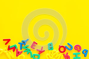 Alphabet for kids concept. English letters in disorder on yellow background top view copy space