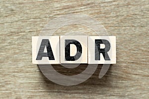 Alphabet letter block in word ADR Abbreviation of adverse drug reaction on wood background