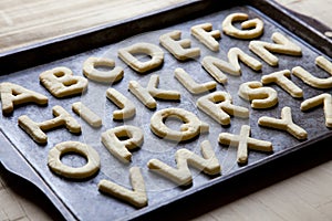 Alphabet letter shaped cookies on baking tray