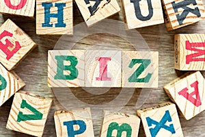 Alphabet letter in word biz (abbreviation of business) with another on wood background