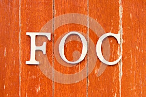Alphabet in word FOC Abbreviation of Free of charge on old red color wood plate background photo