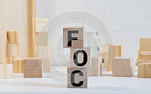 Alphabet letter in word FOC Abbreviation of Free of charge on wood background photo