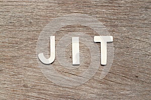 Alphabet letter in word JIT abbreviation of just in time on wood background