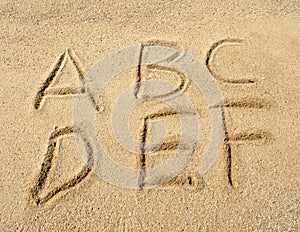 Alphabet letters in sand on beach