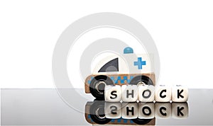alphabet letters spelling the word shock and a toy ambulance