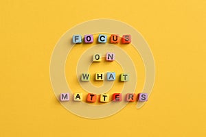 Alphabet letters with text FOCUS ON WHAT MATTERS isolated on yellow background