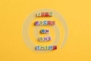 Alphabet letters with text JUST FOCUS ON ONE THING. Motivational quote photo