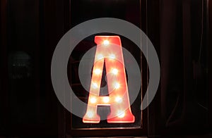 Alphabet letters in vintage style with glowing bulbs inside. Backlit marquee letters illuminated marquee letters name of