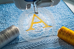 Alphabet logo on towel in hoop of embroidery machine