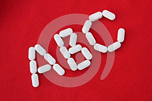 Alphabet made of pills on a red background. Abc from drugs. Vitamins White pills without an inscription. generics, pharmacy and m